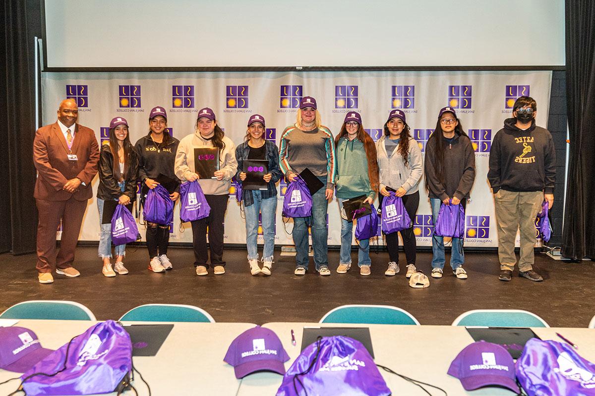 Students at national Signing day holding bags and wearing hats
