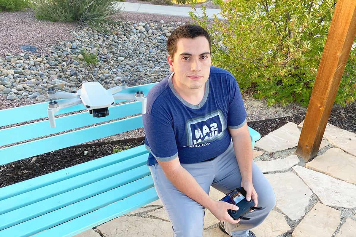 SUAS program graduate Josh Bishop operates a drone in outdoor space.